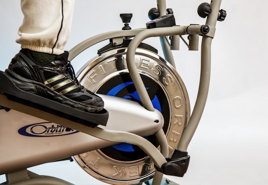 Precor elliptical cross-trainer close-up showing ground-level foot pedals and handlebars