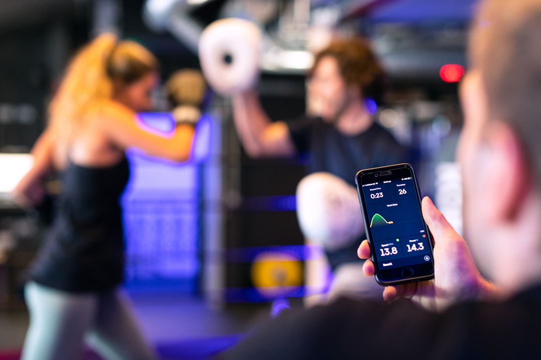 fitness app on smartphone screen showing workout programme in gym