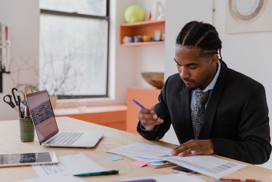 fitness business owner reviewing digital training manual on laptop in gym office