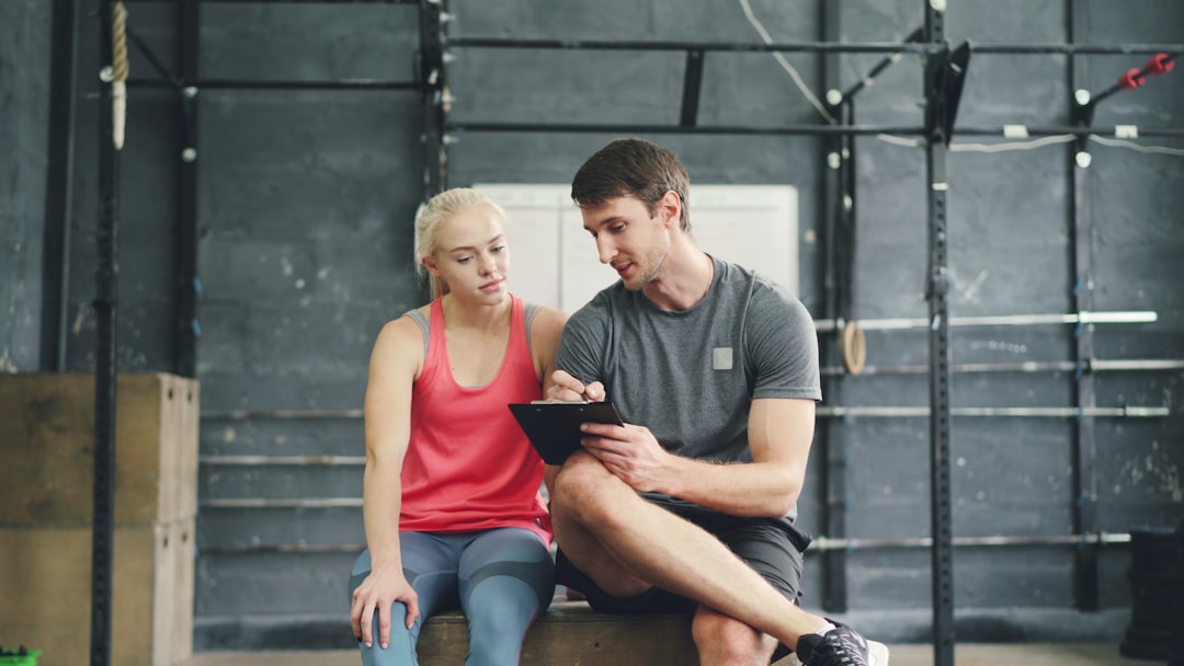 fitness coach reviewing client progress charts on tablet app