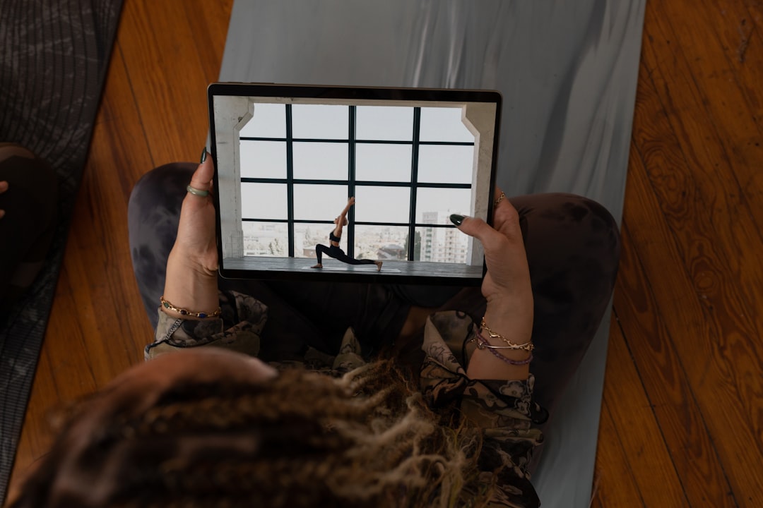 person doing yoga in front of a large mirror screen displaying an instructor