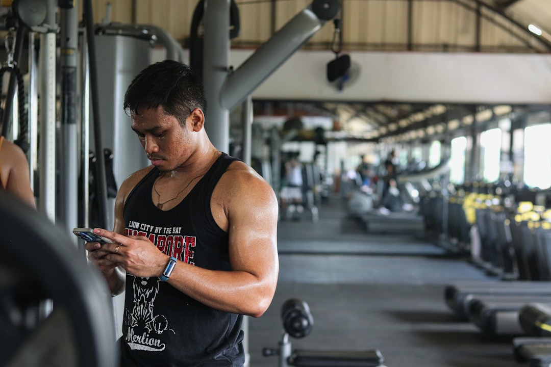 person using smartphone app during gym workout session