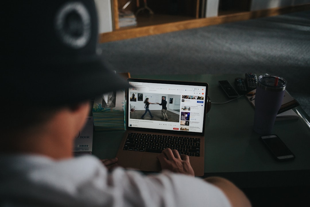 person working out at home on laptop following a fitness class with friends visible on screen