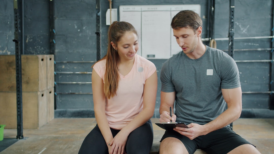 personal trainer reviewing client progress data on tablet in gym setting