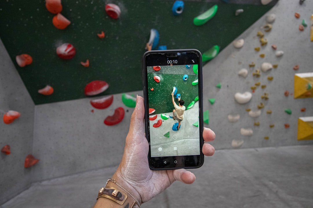 rock climbing training app on smartphone at indoor climbing wall