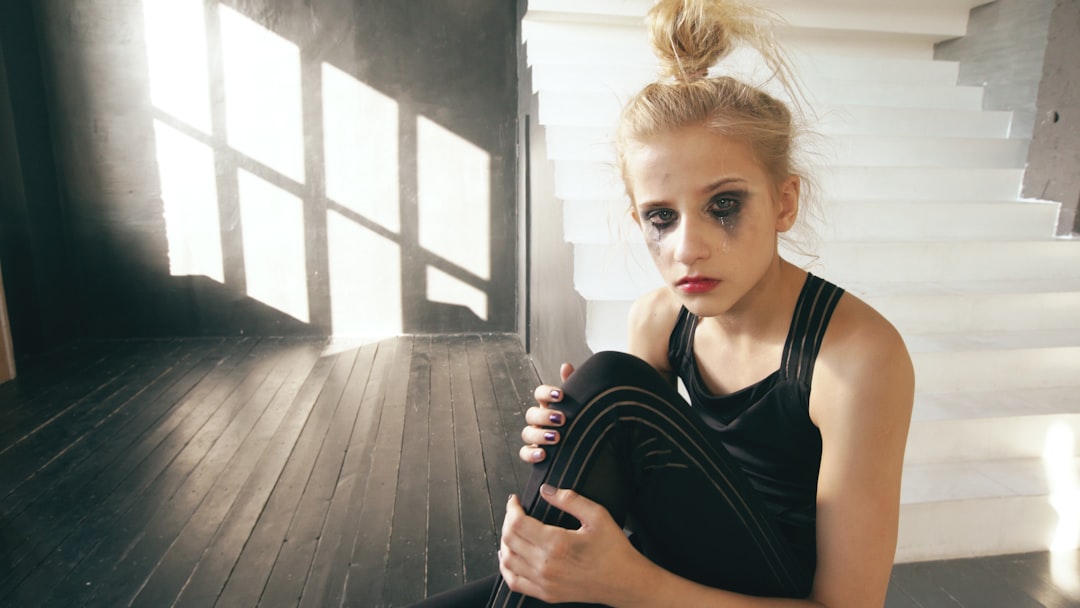 runner sitting on floor using leg compression recovery device after race
