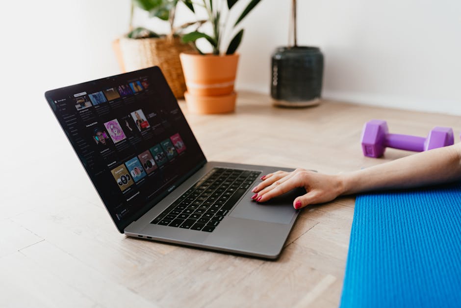 woman doing yoga at home on laptop with Equinox+ fitness app streaming