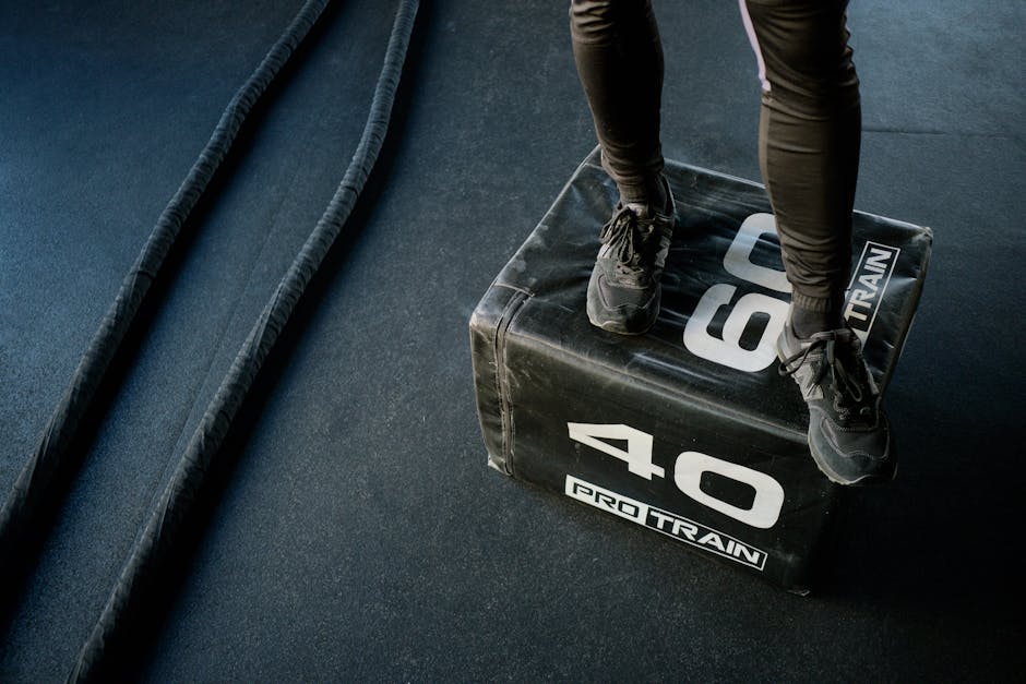 Therabody Theragun Pro device on gym floor with athlete in background