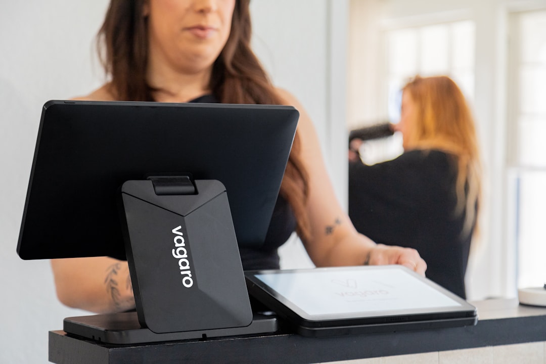 fitness studio owner reviewing software on laptop at front desk