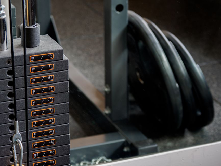 Close-up of Pulse Fitness cable machine weight stack and cable pulley system