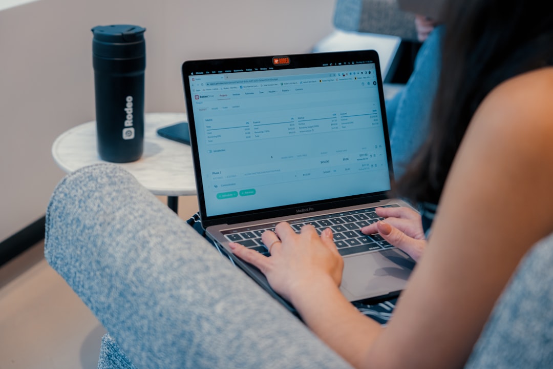 personal trainer using fitness coaching software on laptop