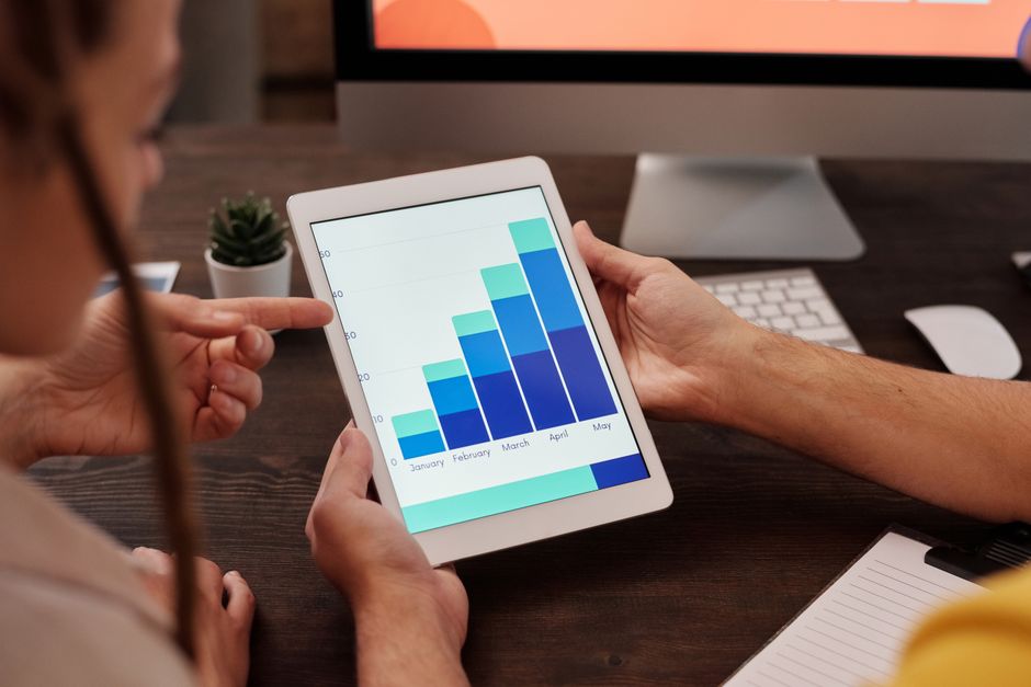 gym owner reviewing software analytics on tablet at reception desk UK