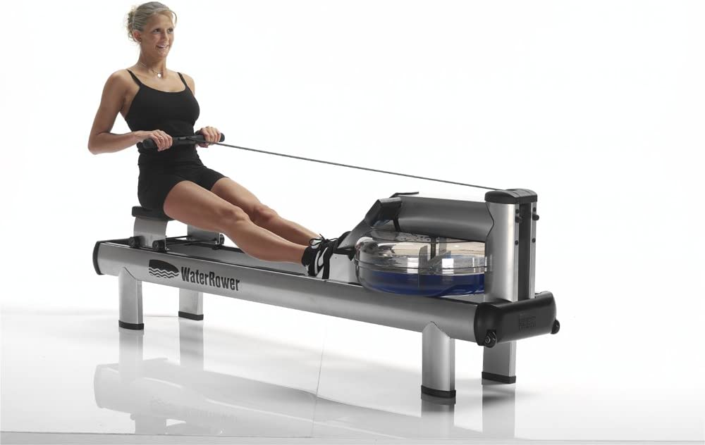 Person in rowing position on a WaterRower Metallic rowing machine, silver aluminium frame